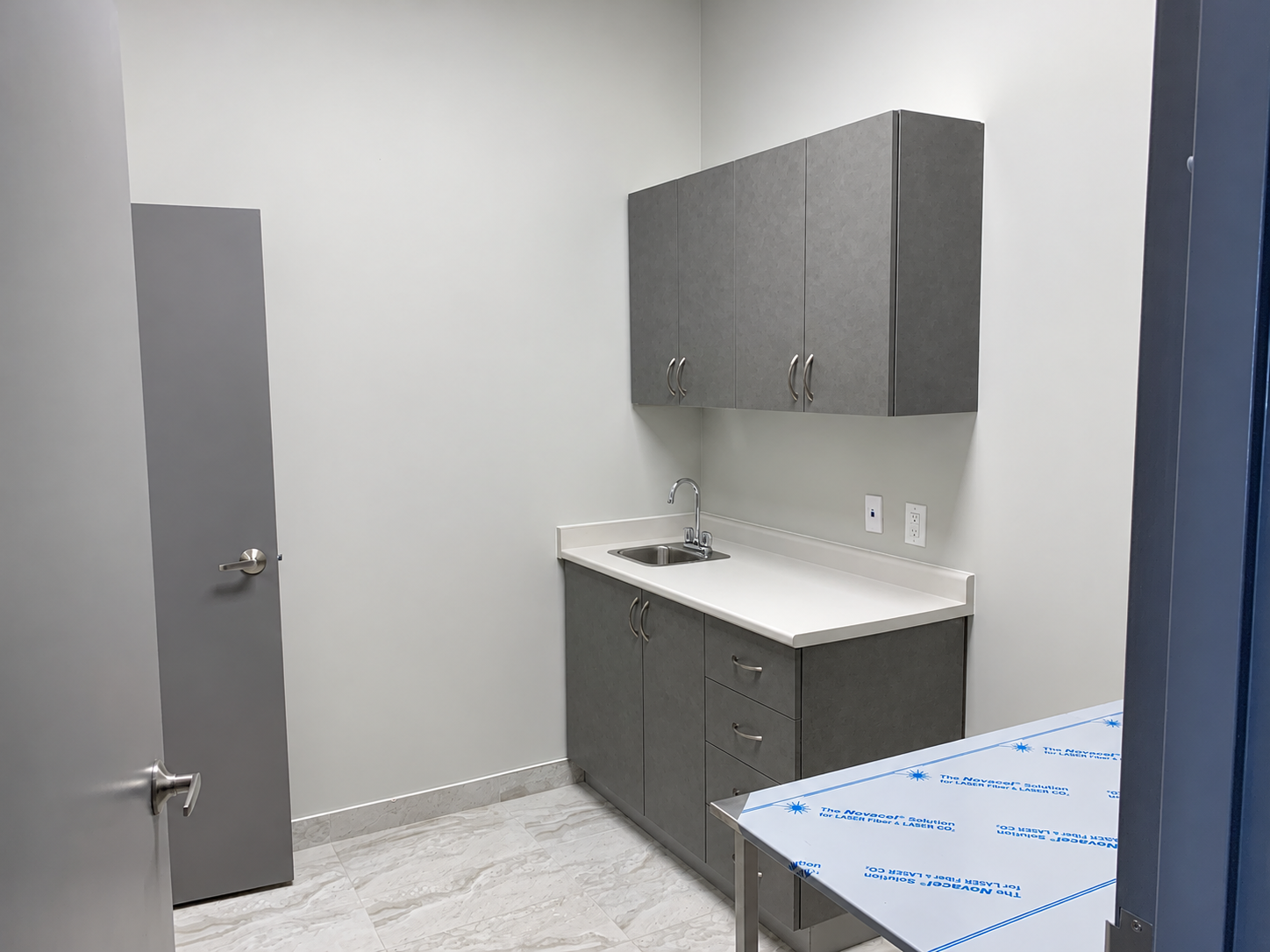 Clinic room near completion, with protective film still on the foreground work surface.
